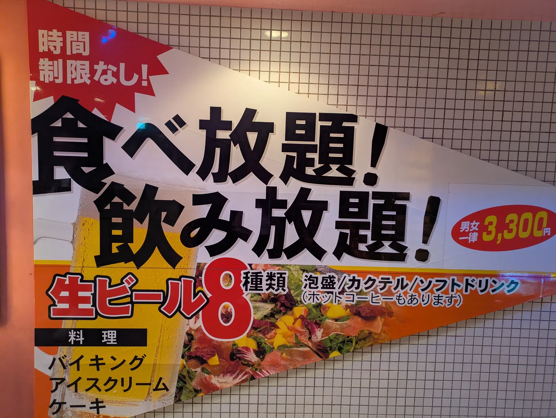 「時間制限なし！食べ放題！飲み放題！男女一律3,300円 生ビール8種類」と書かれたバイキング居酒屋リオの看板